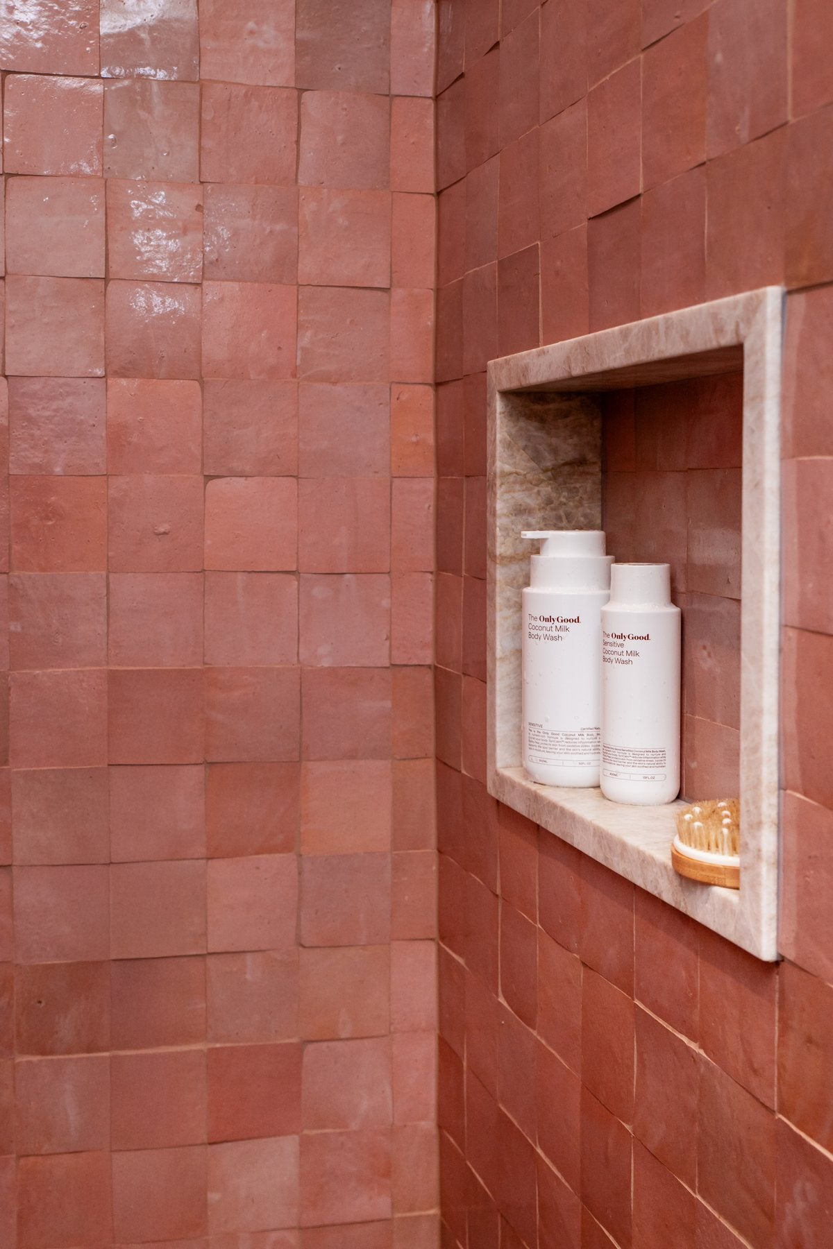 Only Good® Coconut Milk hand and body wash in a terracotta shower niche.