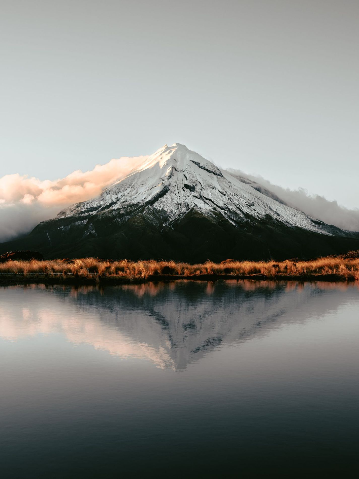 Mount Taranaki in New Zealand, reflected in a lake.