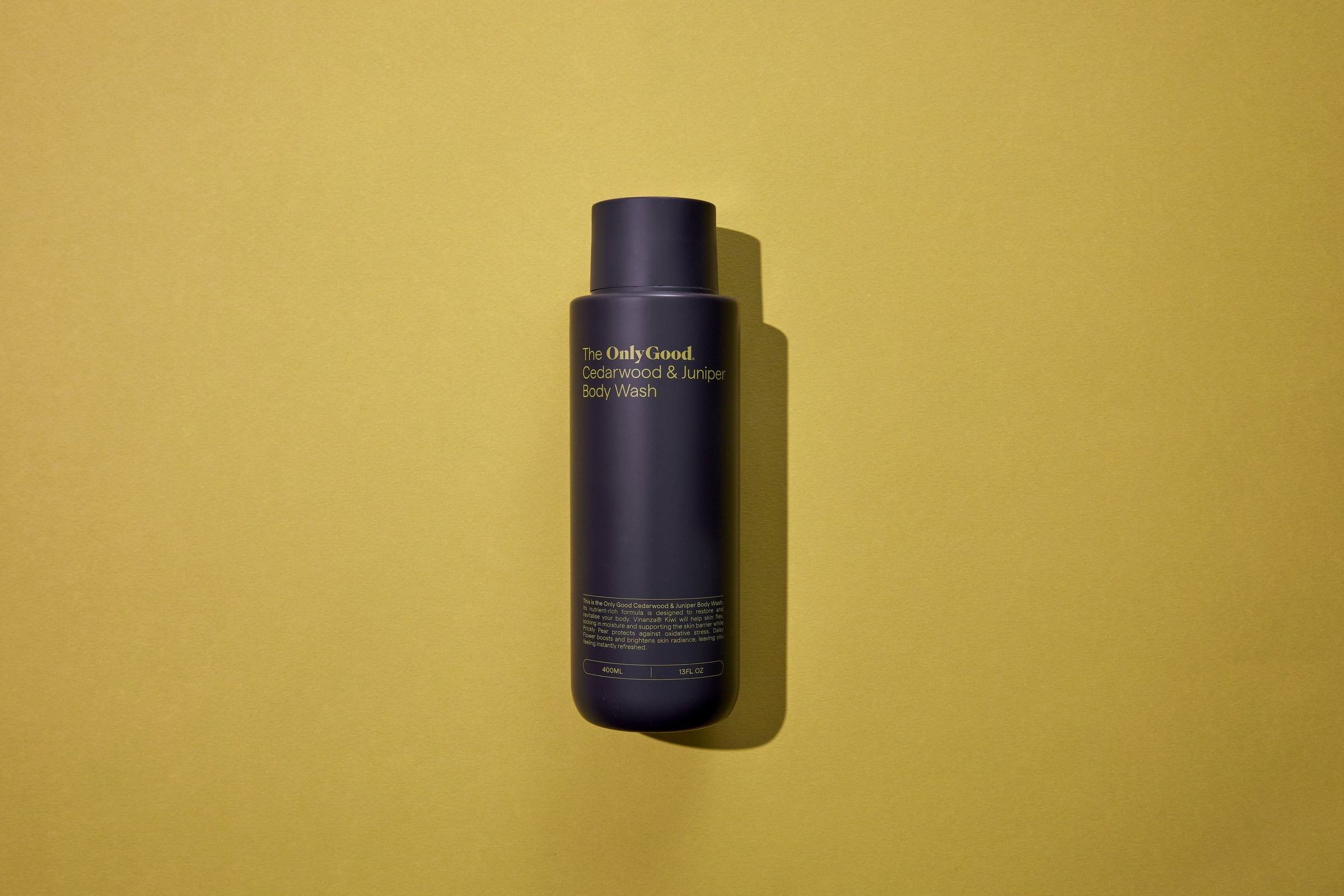 The Cedarwood and Juniper Body Wash lying on yellow-green paper.