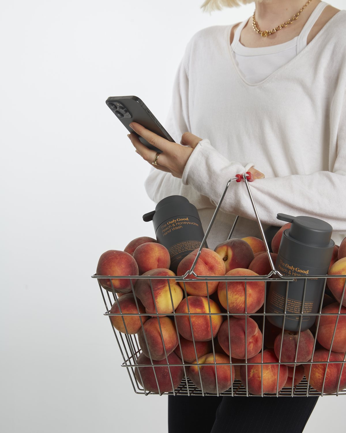 A guest carrying a basket of peaches and the Peach and Honeysuckle hand wash home.