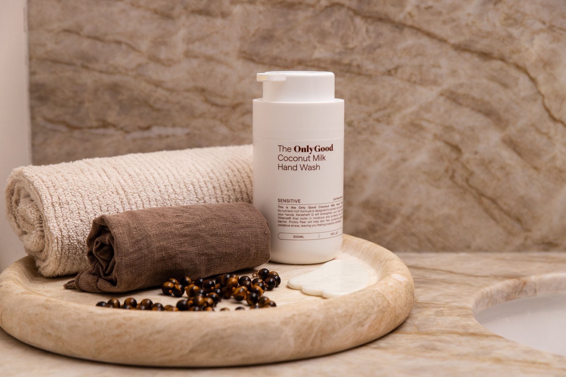 Only Good&reg; Coconut Milk Hand Wash on a stone tray with a folded towel.